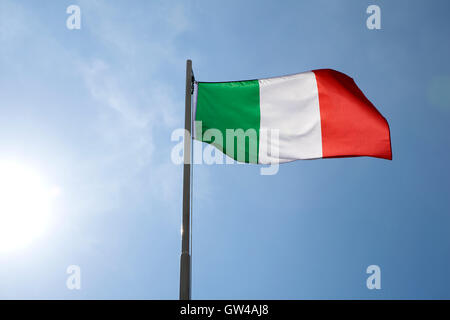 Bandiera nazionale dell'Italia su un pennone di fronte blu cielo Foto Stock