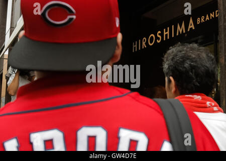 Carpa di Hiroshima Baseball team linea di ventole fino al di fuori di Hiroshima Shop del marchio TAU in Ginza a Settembre 11, 2016, Tokyo, Giappone. Centinaia di carpe ventole schierate dalla mattina presto al di fuori di Hiroshima marchio TAU negozio per acquistare la vittoria di t-shirt dopo Hiroshima Baseball team ha ottenuto il suo primo centro di titolo di campionato in venticinque anni dopo aver battuto il Yomiuri Giants 6-4 il Sabato, Settembre 10. © Rodrigo Reyes Marin/AFLO/Alamy Live News Foto Stock