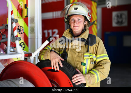 Mannheim, Germania. 24 Ago, 2016. Firewoman Lisa-Katharina Roeck sorge accanto a un motore Fire a sud della stazione dei vigili del fuoco a Mannheim, Germania, 24 agosto 2016. Foto: Uwe Anspach/dpa/Alamy Live News Foto Stock