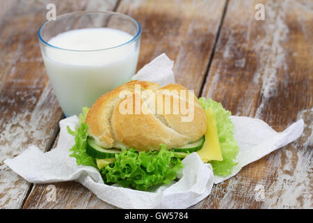 Semplice pranzo costituito da formaggio rotolo con lattuga e bicchiere di latte Foto Stock