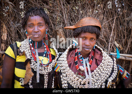 Due donne Hamer al Key Afer mercato nella valle dell'Omo del sud Etiopia vestito in cowrie tradizionali ornamenti della shell Foto Stock