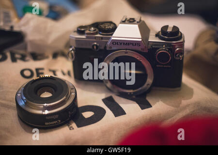 Olympus OM10 e fotocamera Canon 40mm F2.8 lente appoggiata su tote bag. Foto Stock