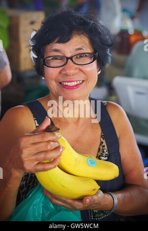 HILO, HAWAII - Lug 13, 2013: una donna non identificato offre le banane in vendita presso l'Hilo farmers market sulla luglio 13, 2013. Foto Stock