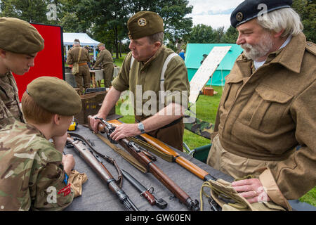 Un 1940 giornata del patrimonio con il vecchio soldato dimostrando come caricare un fucile di cadetti dell esercito Foto Stock