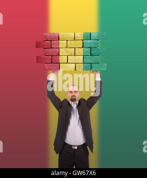 Imprenditore tenendo un grande pezzo di un muro di mattoni Foto Stock