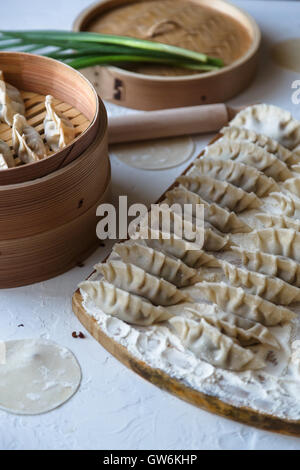 Materie in casa gnocchi Cinesi sulla tavola di legno. Foto Stock