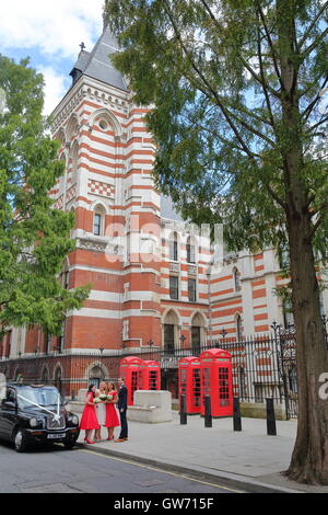 Un uomo e tre giovani donne in posa prima di una cerimonia di matrimonio su Carey Street , Londra, Gran Bretagna Foto Stock