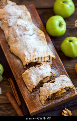 In casa lo strudel di mele con mele, uva passa e noci, vegetariana deliziosa pasticceria rustico su pannello di legno Foto Stock