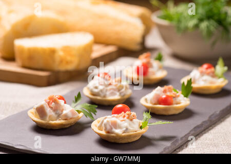 Crostini, antipasto con crema insalata di pollo servito su una piastra di ardesia Foto Stock