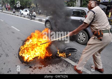 Manifestanti masterizzare pneumatico durante il Nationwide strike chiamato dai sindacati di Guwahati, India il 2 settembre 2016 Foto Stock