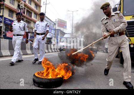 Manifestanti masterizzare pneumatico durante il Nationwide strike chiamato dai sindacati di Guwahati, India il 2 settembre 2016 Foto Stock