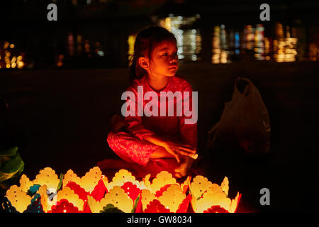 Ragazza giovane vendita candela galleggiante lanterne, Hoi An (Patrimonio Mondiale dell'UNESCO), Vietnam Foto Stock