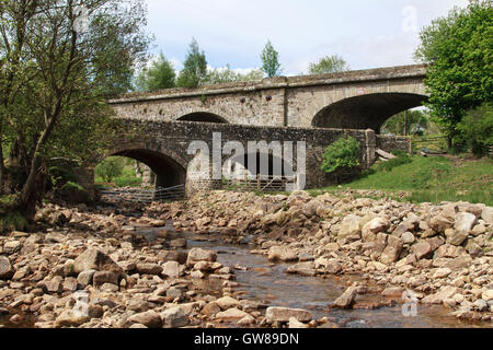 Il Thinhope Burn scorre sotto un ponte stradale e un ponte che trasporta una ferrovia in disuso a Burnstones, South Tyne Valley, Northumberland, Inghilterra Foto Stock