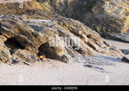 Due persone sedersi in una grotta sulla spiaggia a poco Fistral in Newquay, Cornwall. Foto Stock