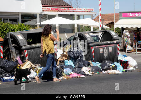 Passeggiate a piedi dalla spazzatura non riscossi in una strada di Roma, Italia Foto Stock