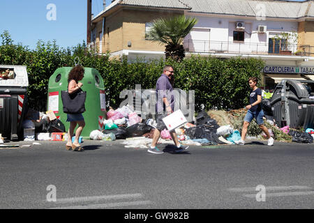 Passeggiate a piedi dalla spazzatura non riscossi in una strada di Roma, Italia Foto Stock