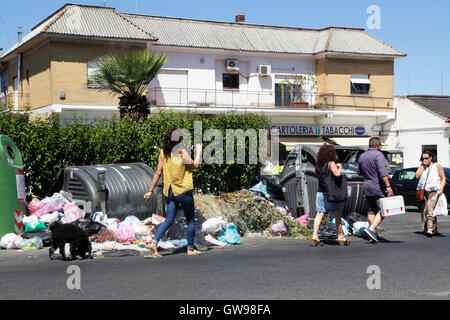 Passeggiate a piedi dalla spazzatura non riscossi in una strada di Roma, Italia Foto Stock