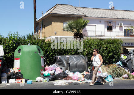 Passeggiate a piedi dalla spazzatura non riscossi in una strada di Roma, Italia Foto Stock