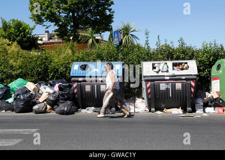 Passeggiate a piedi dalla spazzatura non riscossi in una strada di Roma, Italia Foto Stock