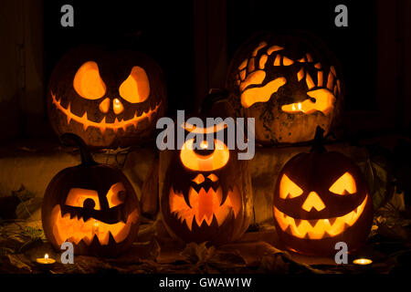 Composizione della foto da cinque zucche di Halloween. Jack, terribili mani, amareggiata, un ciclope e male la zucca contro un vecchio w Foto Stock
