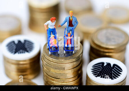 Le figure in miniatura di una famiglia su una pila di monete, simbolico foto famiglia denaro, Miniaturfiguren einer Familie auf einem Muenzstapel, Foto Stock