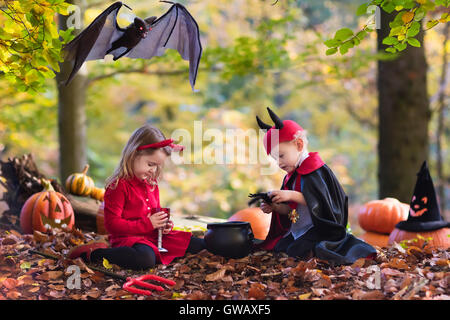 Due bambini divertenti indossando devil e vampire costume rosso con corna e trident trucco o trattamento di Halloween. Foto Stock