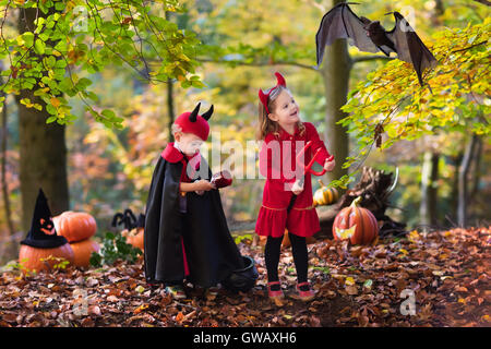 Due bambini divertenti indossando devil e vampire costume rosso con corna e trident trucco o trattamento di Halloween. Foto Stock