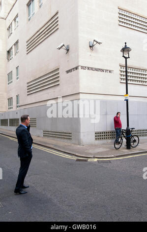 Due estranei essendo sorvegliato da telecamere di sorveglianza, Old Burlington Street, Londra Foto Stock