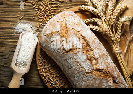 In casa della pagnotta di pane con gli ingredienti sul tavolo di legno Foto Stock