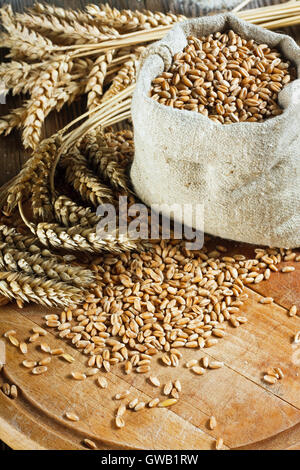 Chicco di grano in piccola borsa sul tavolo in legno Foto Stock