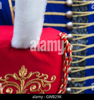 Dettagli della red ussaro busby cappello con pelliccia bianca plume contro lo sfondo di colore blu dolman giacca. Foto Stock