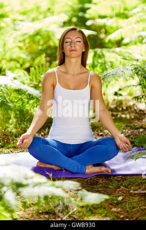 Bella donna che pratica yoga all'aperto Foto Stock