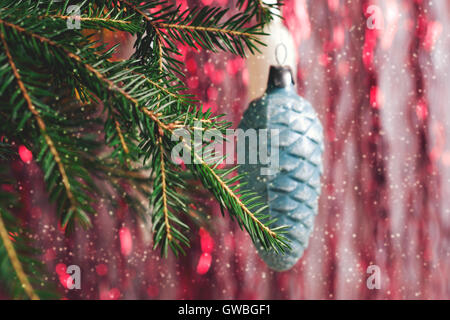 Festa di Natale sfondo. Giocattolo di Natale sull'albero di Natale con caduta di neve Foto Stock