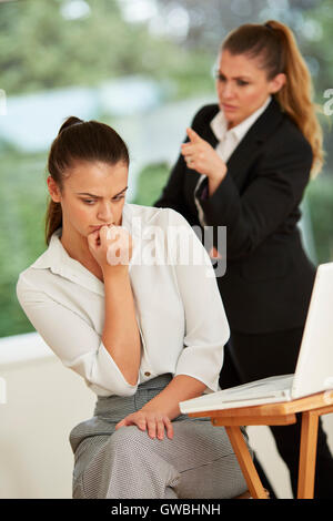 Un collega di lavoro intimidatorio un altro Foto Stock