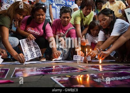 Manila, Filippine. Xiii Sep, 2016. Le donne del gruppo diritti Gabriela condurre una candela cerimonia di illuminazione, lungo Taft Avenue a Manila, come la chiamano per Presidente Duterte l'aiuto nel salvataggio di Mary Jane Veloso dall'esecuzione in Indonesia. Credito: J Gerard Seguia/Pacific Press/Alamy Live News Foto Stock