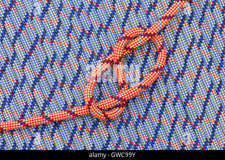 Colore luminoso corda con una figura a otto nodi su uno sfondo di funi Foto Stock