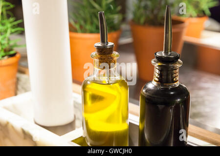 Olio di oliva e aceto balsamico in bottiglie di vetro su un tavolo in un ristorante Foto Stock