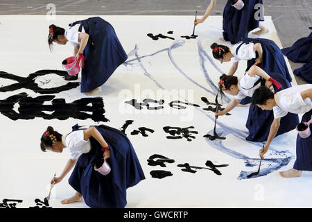 Giapponese studentesse compete per la tecnologia scritta in una calligrafia Kagawa Festival Foto Stock
