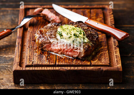 Grigliata di mezzo raro steak bistecca con burro alle erbe sul bordo di taglio Foto Stock
