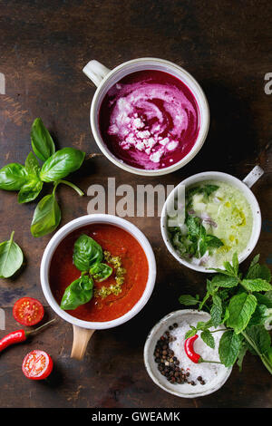 Varietà di freddo zuppe vegetariani gazpacho cetriolo con la menta, barbabietole rosse con il formaggio feta, pomodoro con pesto verde, servita con sé Foto Stock