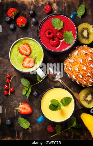 Vetri di vari frullati con cannucce e frutti. Sana colazione vegetariana o materie mangiare concept Foto Stock