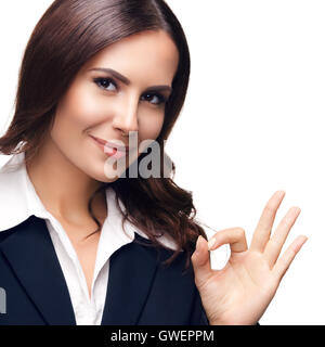 Sorridenti bella giovane imprenditrice che illustra bene il gesto, isolata contro uno sfondo bianco Foto Stock