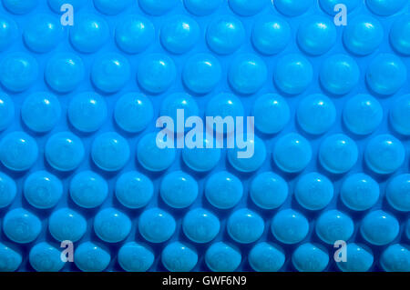 Abstract closeup di blu brillante bolla di copertura per piscina rotonda con accidentato texture di superficie. Foto Stock