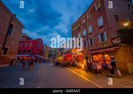 Venezia, Italia - 18 giugno 2015: Ristoranti via di Venezia, i turisti che cercano il posto migliore. Cielo blu quasi Foto Stock