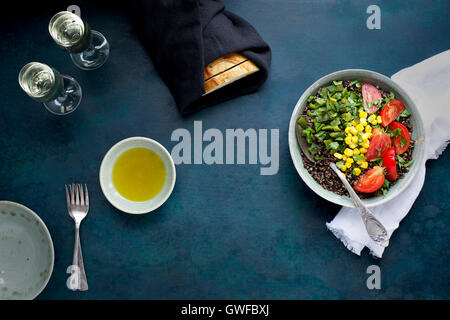 Poblano arrosto di Quinoa e rabboccato con mais, pomodori e coriandolo. Servita con vino bianco, olio d'oliva e pane. Fotografato da t Foto Stock