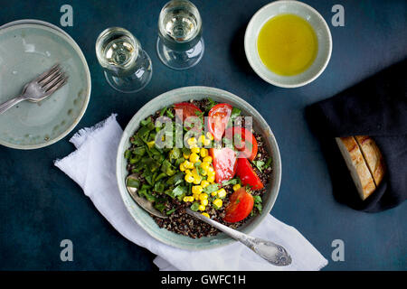 Poblano arrosto di Quinoa e rabboccato con mais, pomodori e coriandolo. Servita con vino bianco, olio d'oliva e pane. Fotografato da t Foto Stock