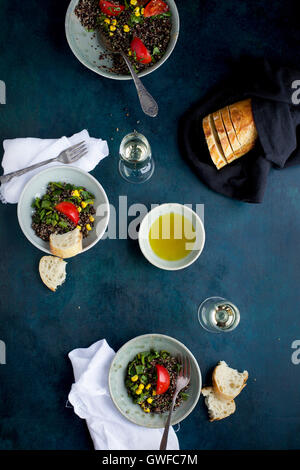 Poblano arrosto di Quinoa e rabboccato con mais, pomodori e coriandolo. Servita con vino bianco, olio d'oliva e pane. Fotografato da t Foto Stock