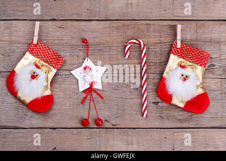 Le decorazioni di Natale appesa sopra lo sfondo di legno, carta di festa Foto Stock