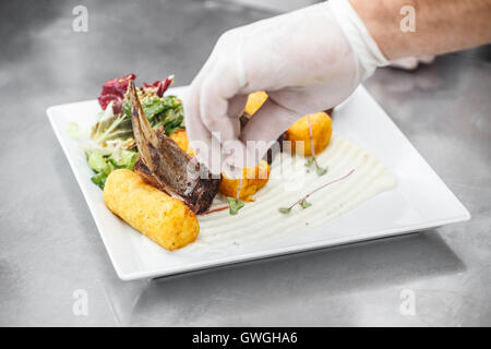 Costolette di agnello serviti sulla piastra bianca con purè di patate crocchette riempito Foto Stock