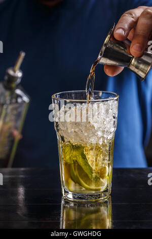 Barista versando forte bevanda alcolica nel vetro Foto Stock